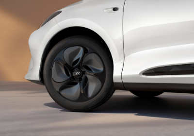 Close-up of a white car's front left tyre and alloy wheel design.